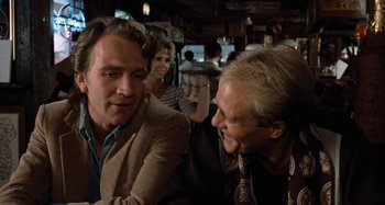 Movie still from “Body Double” (1984), directed by Brian De Palma – Two men are talking to each other in a bar; Close Up shot, Over the shoulder angle