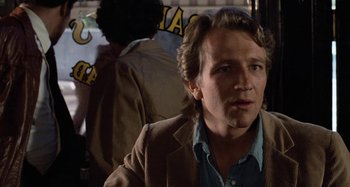 Movie still from “Body Double” (1984), directed by Brian De Palma – A person wearing a suit and tie; Close Up shot, Over the shoulder angle