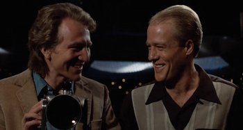 Movie still from “Body Double” (1984), directed by Brian De Palma – A couple of men standing next to each other; Close Up shot, Low angle