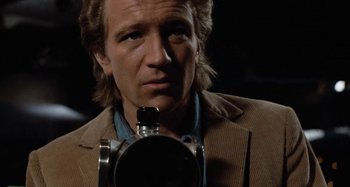 Movie still from “Body Double” (1984), directed by Brian De Palma – A person holding a camera; Close Up shot, Low angle