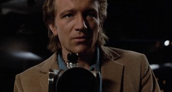 Movie still from “Body Double” (1984), directed by Brian De Palma – A person holding a camera; Close Up shot, Low angle