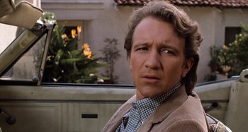 Movie still from “Body Double” (1984), directed by Brian De Palma – A person wearing a suit and tie; Close Up shot, Over the shoulder angle