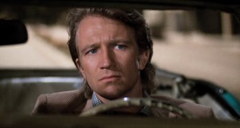 Movie still from “Body Double” (1984), directed by Brian De Palma – A person sitting in a car; Close Up shot, Low angle