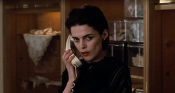 Movie still from “Body Double” (1984), directed by Brian De Palma – A woman talking on a phone while wearing a black dress; Close Up shot, Low angle