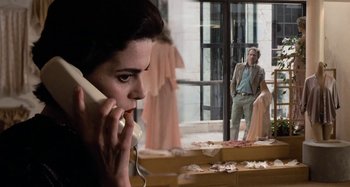 Movie still from “Body Double” (1984), directed by Brian De Palma – A woman talking on a phone while a man looks on; Medium shot, Over the shoulder angle