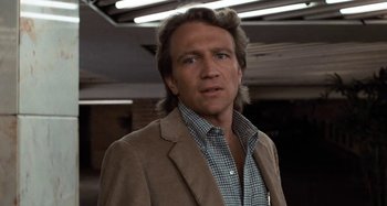 Movie still from “Body Double” (1984), directed by Brian De Palma – A person wearing a suit and tie; Close Up shot, Low angle