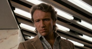 Movie still from “Body Double” (1984), directed by Brian De Palma – A person wearing a suit and tie; Close Up shot, Low angle