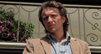 Movie still from “Body Double” (1984), directed by Brian De Palma – A person wearing a suit and tie; Close Up shot, Low angle