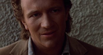 Movie still from “Body Double” (1984), directed by Brian De Palma – A person wearing a shirt and jacket; Close Up shot, Over the shoulder angle