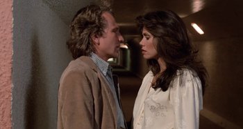 Movie still from “Body Double” (1984), directed by Brian De Palma – A man and a woman standing next to each other; Close Up shot, Over the shoulder angle