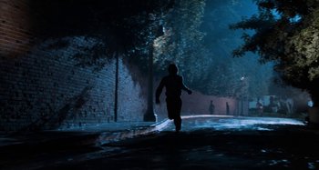 Movie still from “Body Double” (1984), directed by Brian De Palma – A person walking down a street at night; Wide shot, High angle
