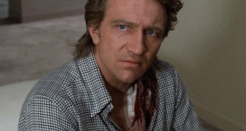 Movie still from “Body Double” (1984), directed by Brian De Palma – A person wearing a shirt and tie; Close Up shot, Low angle