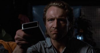 Movie still from “Body Double” (1984), directed by Brian De Palma – A person holding a cell phone; Close Up shot, Low angle