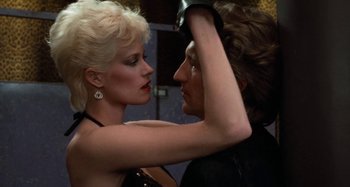 A man and a woman are touching each other's hair