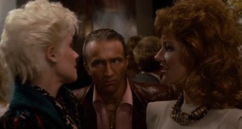 Movie still from “Body Double” (1984), directed by Brian De Palma – A man and two women talking to each other in a room; Close Up shot, Over the shoulder angle