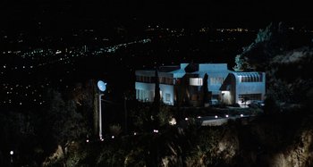 Movie still from “Body Double” (1984), directed by Brian De Palma – A building with lights on top of a hill at night; Extreme Wide shot, High angle