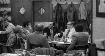Movie still from “Broadway Danny Rose” (1984), directed by Woody Allen – A black and white photo of a group of men sitting around a table; Wide shot, Over the shoulder angle
