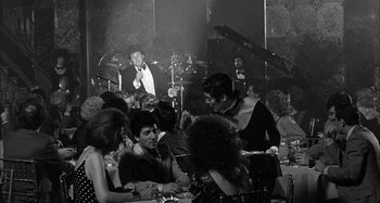 Movie still from “Broadway Danny Rose” (1984), directed by Woody Allen – A black and white photo of people sitting at a table; Medium shot, Over the shoulder angle