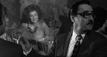 Movie still from “Broadway Danny Rose” (1984), directed by Woody Allen – A black and white photo of a man in a suit; Close Up shot, Over the shoulder angle