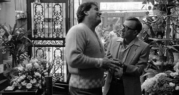 Movie still from “Broadway Danny Rose” (1984), directed by Woody Allen – A man and a man standing next to each other; Medium shot, Over the shoulder angle