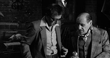 Movie still from “Broadway Danny Rose” (1984), directed by Woody Allen – A man and a woman standing next to each other in a room; Medium shot, Over the shoulder angle