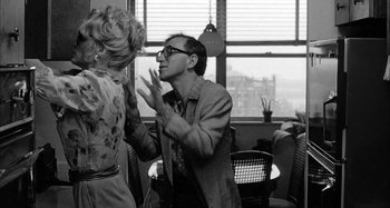 Movie still from “Broadway Danny Rose” (1984), directed by Woody Allen – A man and a woman in a room with a window in the background; Medium shot, Over the shoulder angle