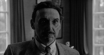 Movie still from “Broadway Danny Rose” (1984), directed by Woody Allen – A black and white photo of a man in a suit and tie; Close Up shot, Over the shoulder angle