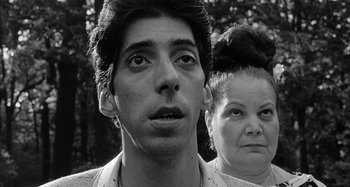 Movie still from “Broadway Danny Rose” (1984), directed by Woody Allen – A man and a woman standing next to each other in front of trees; Close Up shot, Low angle