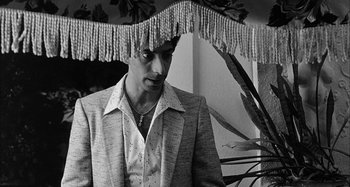 Movie still from “Broadway Danny Rose” (1984), directed by Woody Allen – A black and white photo of a man in a suit; Medium shot, Low angle