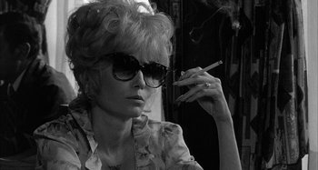 Movie still from “Broadway Danny Rose” (1984), directed by Woody Allen – A woman with sunglasses and a cigarette in her mouth; Close Up shot, Low angle