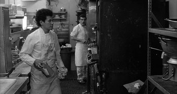 Movie still from “Broadway Danny Rose” (1984), directed by Woody Allen – Two men in a kitchen preparing a meal; Medium shot, Low angle