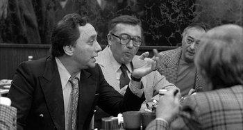 Movie still from “Broadway Danny Rose” (1984), directed by Woody Allen – A group of men sitting around a table; Medium shot, Over the shoulder angle