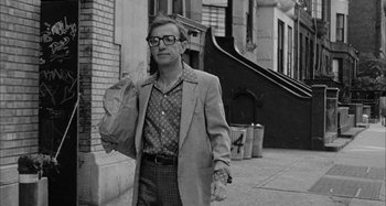 Movie still from “Broadway Danny Rose” (1984), directed by Woody Allen – A black and white photo of a man walking down the street; Medium shot, Low angle