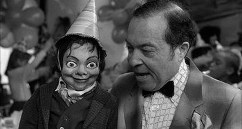 Movie still from “Broadway Danny Rose” (1984), directed by Woody Allen – An old photo of a man and a clown doll; Close Up shot, Over the shoulder angle