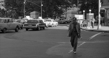 Movie still from “Broadway Danny Rose” (1984), directed by Woody Allen – A black and white photo of a man crossing the street; Wide shot, Over the shoulder angle