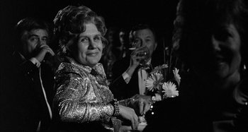 Movie still from “Broadway Danny Rose” (1984), directed by Woody Allen – An older woman is holding a glass of wine; Medium shot, Over the shoulder angle