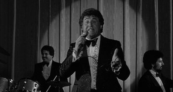 Movie still from “Broadway Danny Rose” (1984), directed by Woody Allen – A black and white photo of a man singing; Medium shot, Low angle