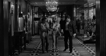 Movie still from “Broadway Danny Rose” (1984), directed by Woody Allen – A group of people standing in a hallway; Wide shot, Low angle