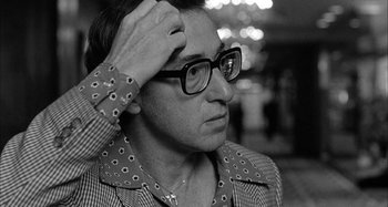 Movie still from “Broadway Danny Rose” (1984), directed by Woody Allen – A black and white photo of a man wearing glasses; Close Up shot, Over the shoulder angle