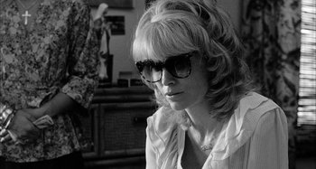 Movie still from “Broadway Danny Rose” (1984), directed by Woody Allen – A black and white photo of a woman wearing glasses; Close Up shot, Over the shoulder angle