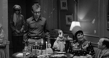Movie still from “Broadway Danny Rose” (1984), directed by Woody Allen – A man and woman sitting at a dinner table with a stuffed animal; Medium shot, Over the shoulder angle