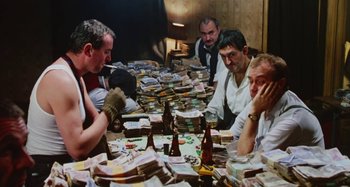 A group of men sitting at a table with lots of money