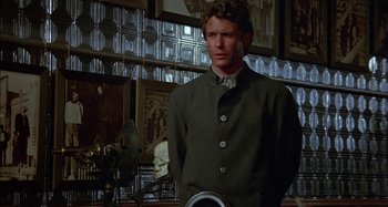 Movie still from “Butch and Sundance: The Early Days” (1979), directed by Richard Lester – A man standing in front of a wall of pictures; Medium shot, Low angle