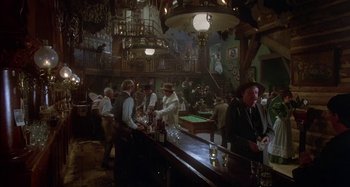 Movie still from “Butch and Sundance: The Early Days” (1979), directed by Richard Lester – A group of men standing around a bar; Wide shot, High angle