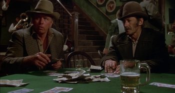 Movie still from “Butch and Sundance: The Early Days” (1979), directed by Richard Lester – Two men sitting at a table playing a card game; Medium shot, High angle