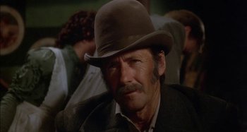 Movie still from “Butch and Sundance: The Early Days” (1979), directed by Richard Lester – An older man wearing a brown hat and a brown jacket; Close Up shot, Low angle