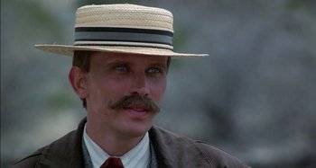 Movie still from “Butch and Sundance: The Early Days” (1979), directed by Richard Lester – A man wearing a straw hat and a suit; Close Up shot, Low angle