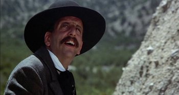 Movie still from “Butch and Sundance: The Early Days” (1979), directed by Richard Lester – A person wearing a suit and a hat; Close Up shot, Low angle