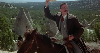 Movie still from “Butch and Sundance: The Early Days” (1979), directed by Richard Lester – A man riding a horse on top of a mountain; Medium shot, Low angle