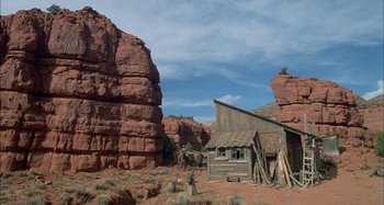 Movie still from “Butch and Sundance: The Early Days” (1979), directed by Richard Lester – An old wooden building in the middle of a desert; Extreme Wide shot, Low angle